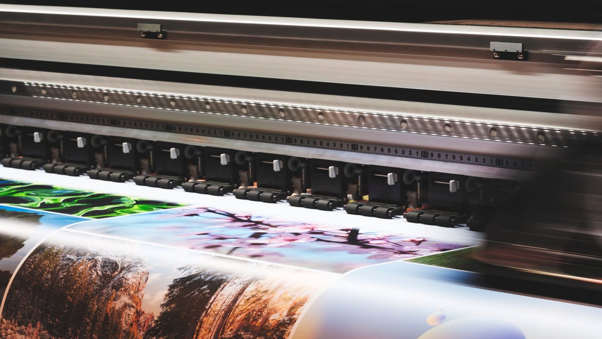 An industrial printing press running, printing a colour image onto paper